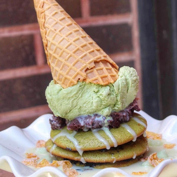 Matcha pancakes with red bean paste, matcha ice cream, a waffle cone, and condensed milk drizzle.